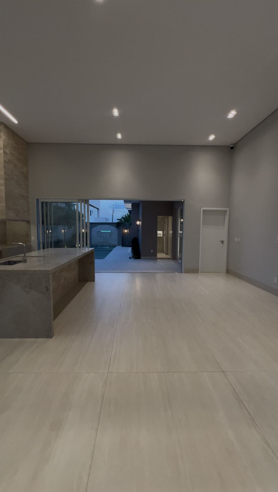 Living amplo integrado à cozinha e à área da piscina